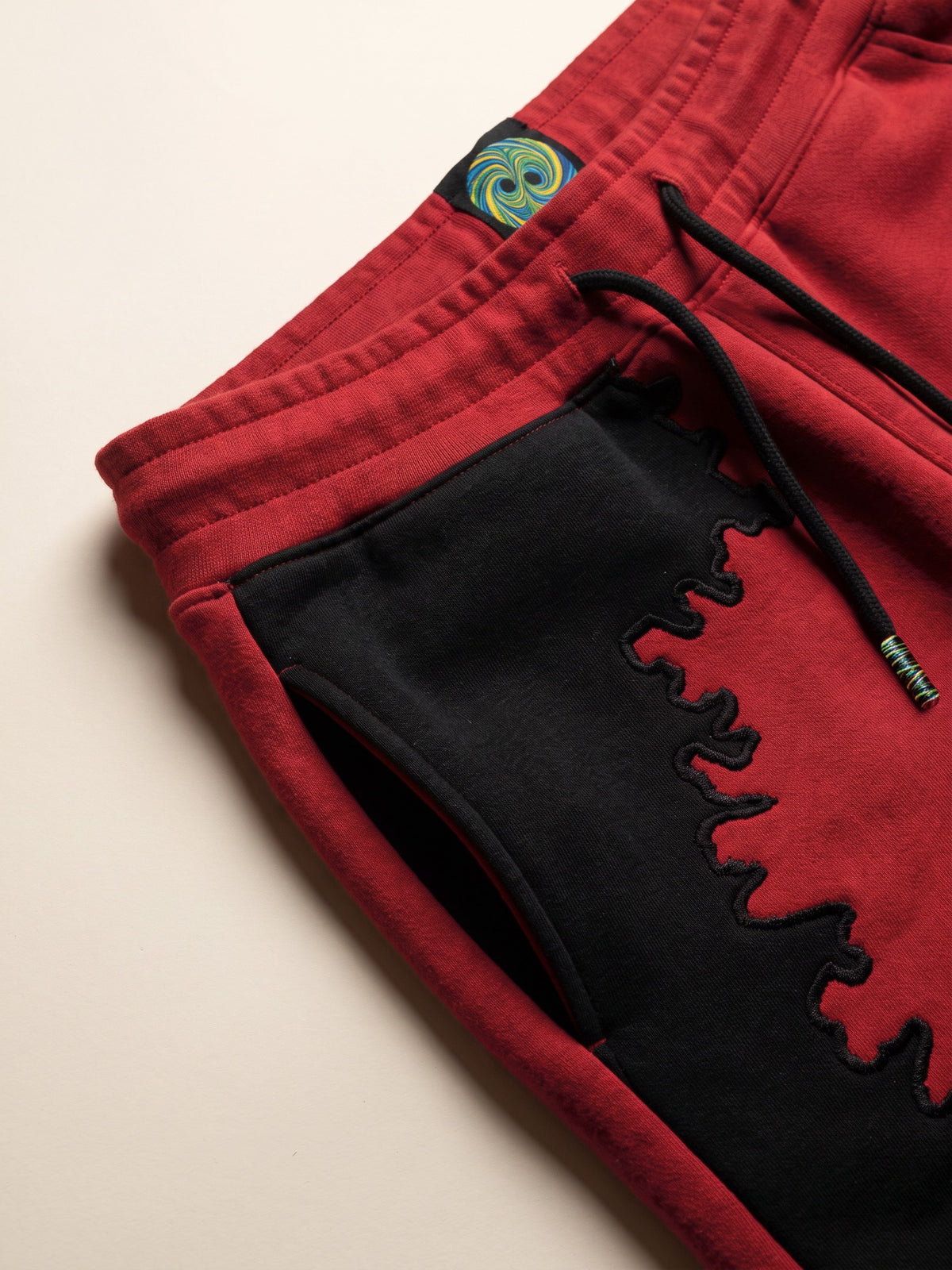 Spill Joggers – Red – waistband, drawcord and side pocket close-up