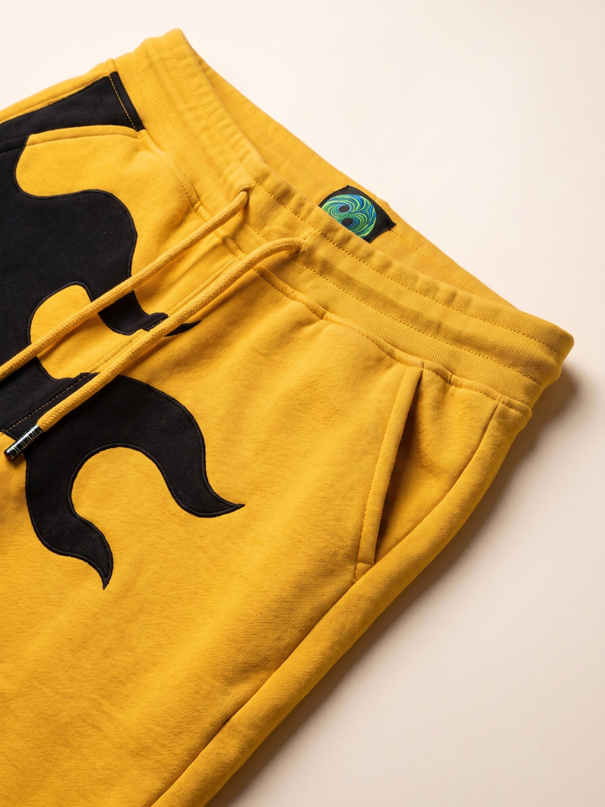 Flame Joggers II – Yellow – waistband, drawcord and flame close-up